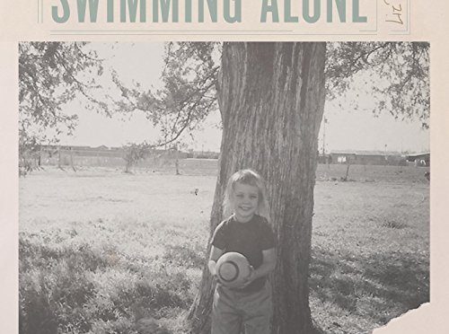 Swimming Alone cover - her as a little kid standing in front of a tree in a black and white setting. it's cool.